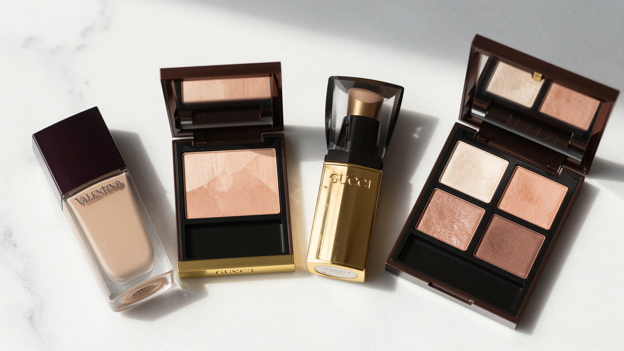 Flat lay of luxury lipsticks, eyeliner, and eyeshadow palette on a white marble surface with natural light.