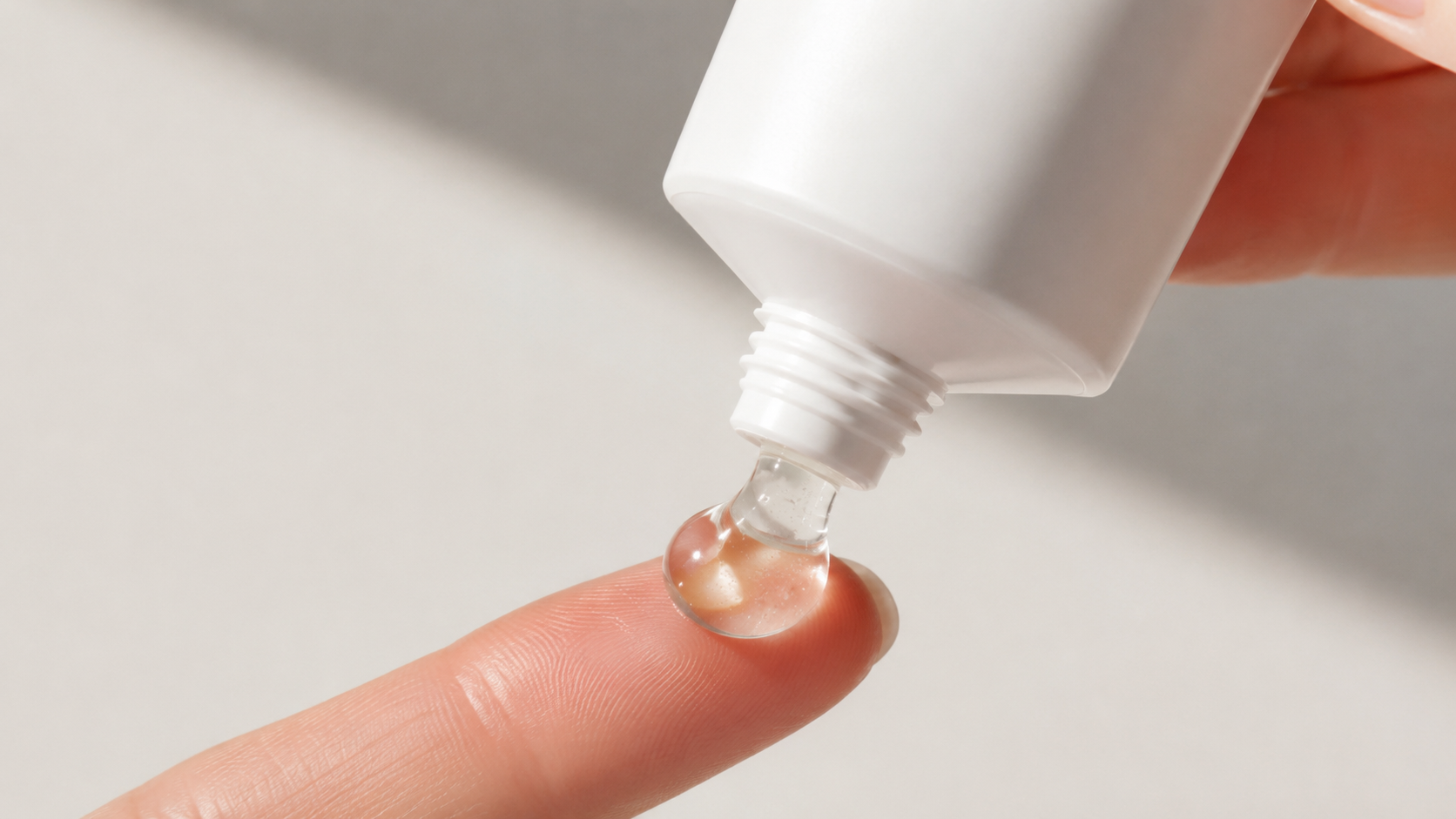 Clear silicone gel on a fingertip being squeezed from a white tube