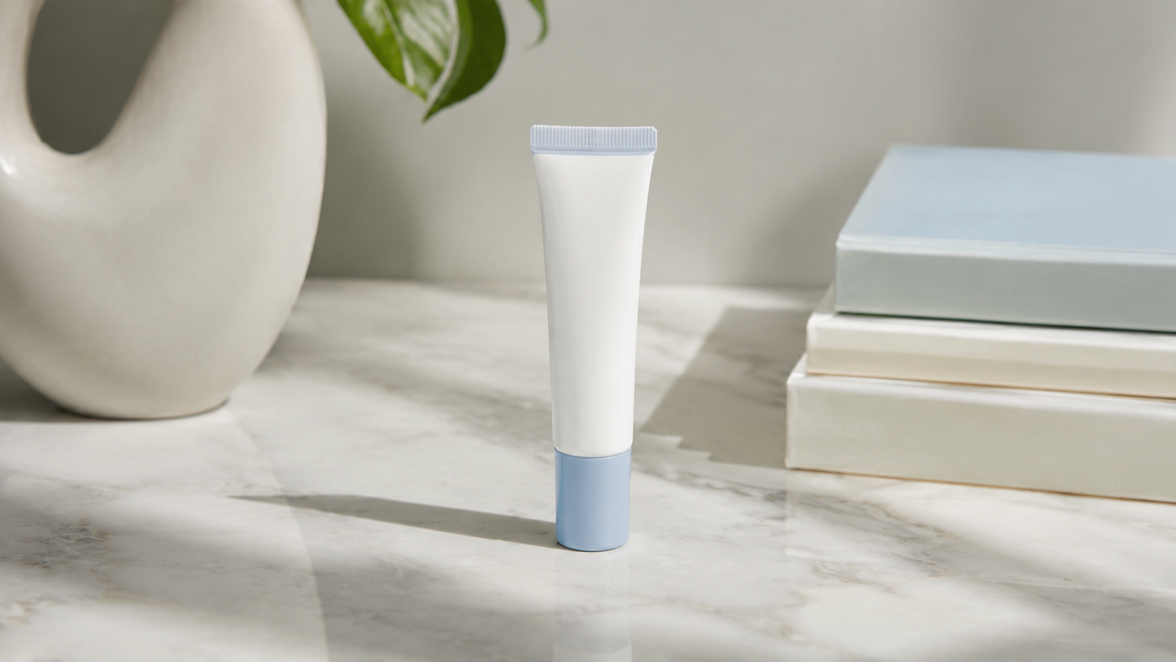 Blue and white ceramide lip balm tube on a marble counter