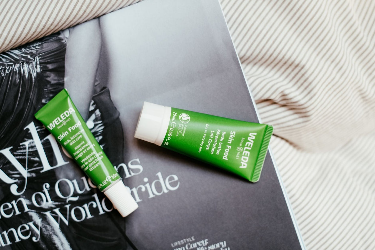 Two Weleda Skin Food tubes placed on a fashion magazine page.