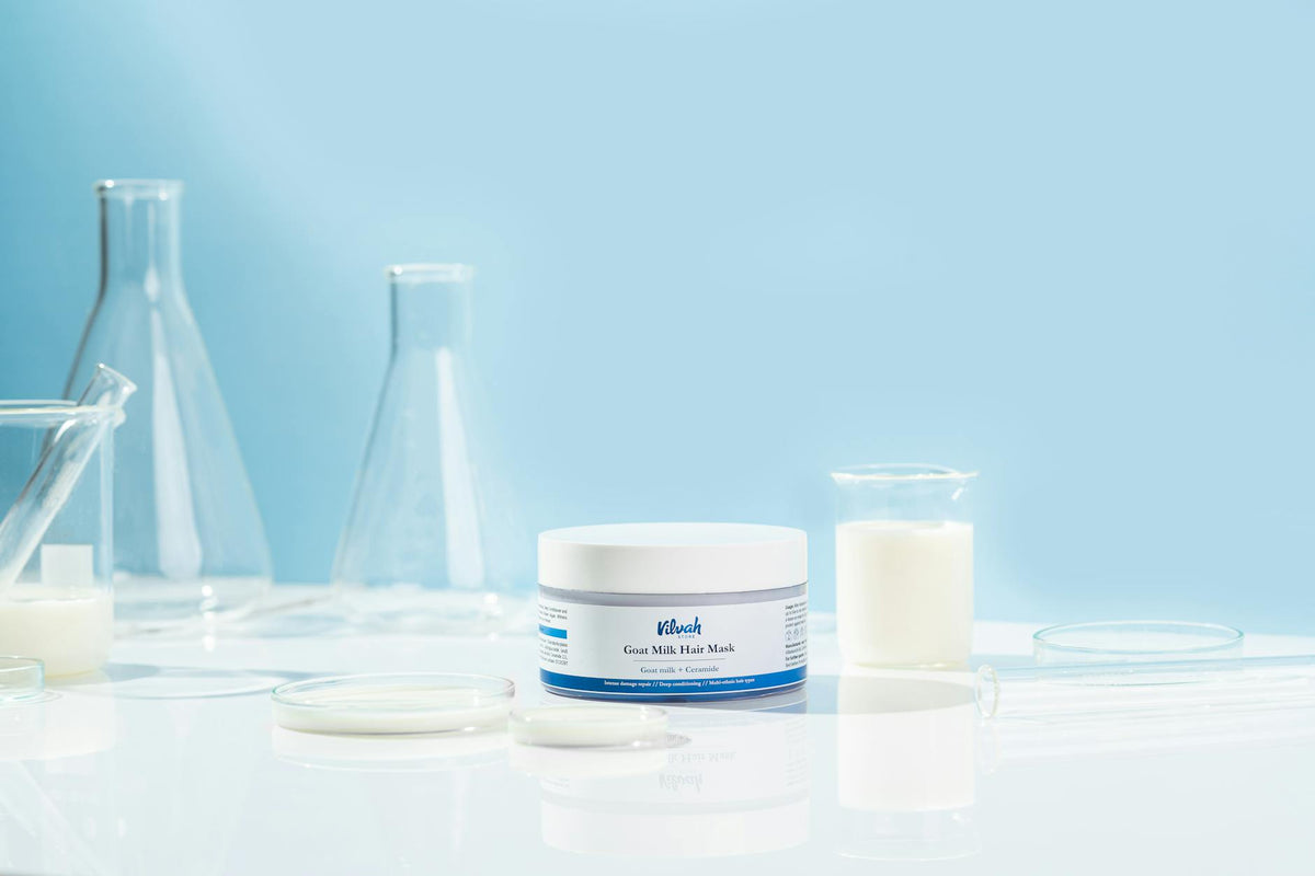 Goat milk hair mask product displayed with lab equipment, emphasizing organic haircare benefits.