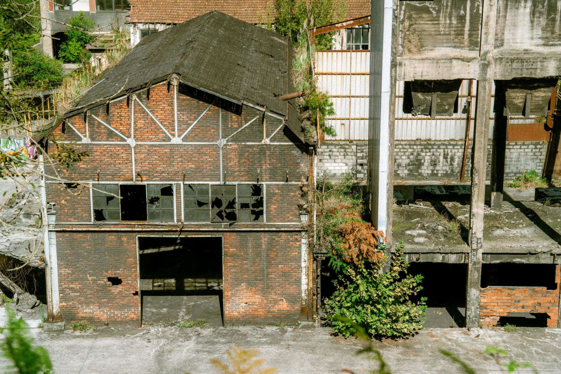 A decaying brick warehouse with broken windows, showcasing urban decay.
