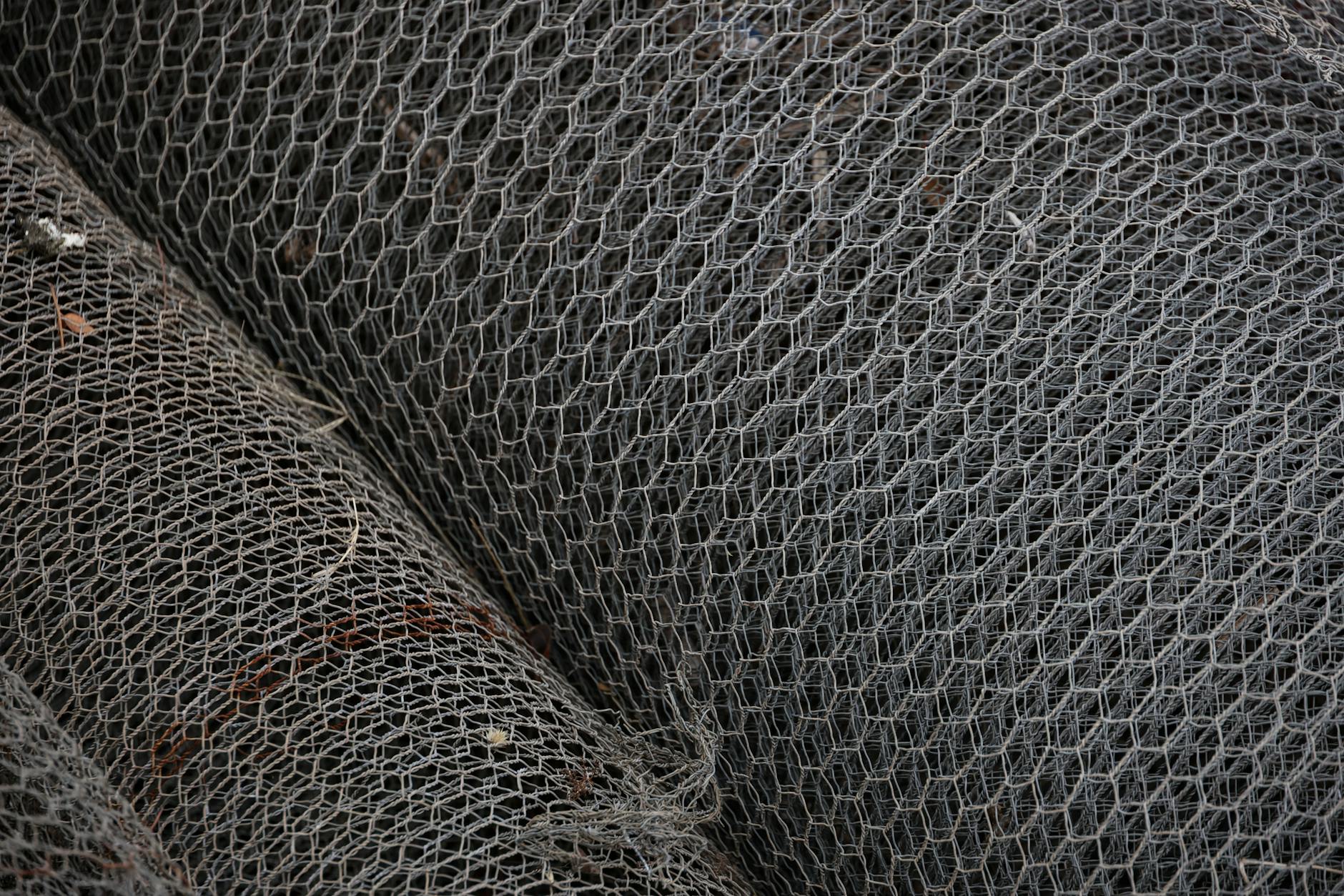 Detailed view of rolled metal wire mesh showcasing intricate patterns, ideal for industrial and construction themes.