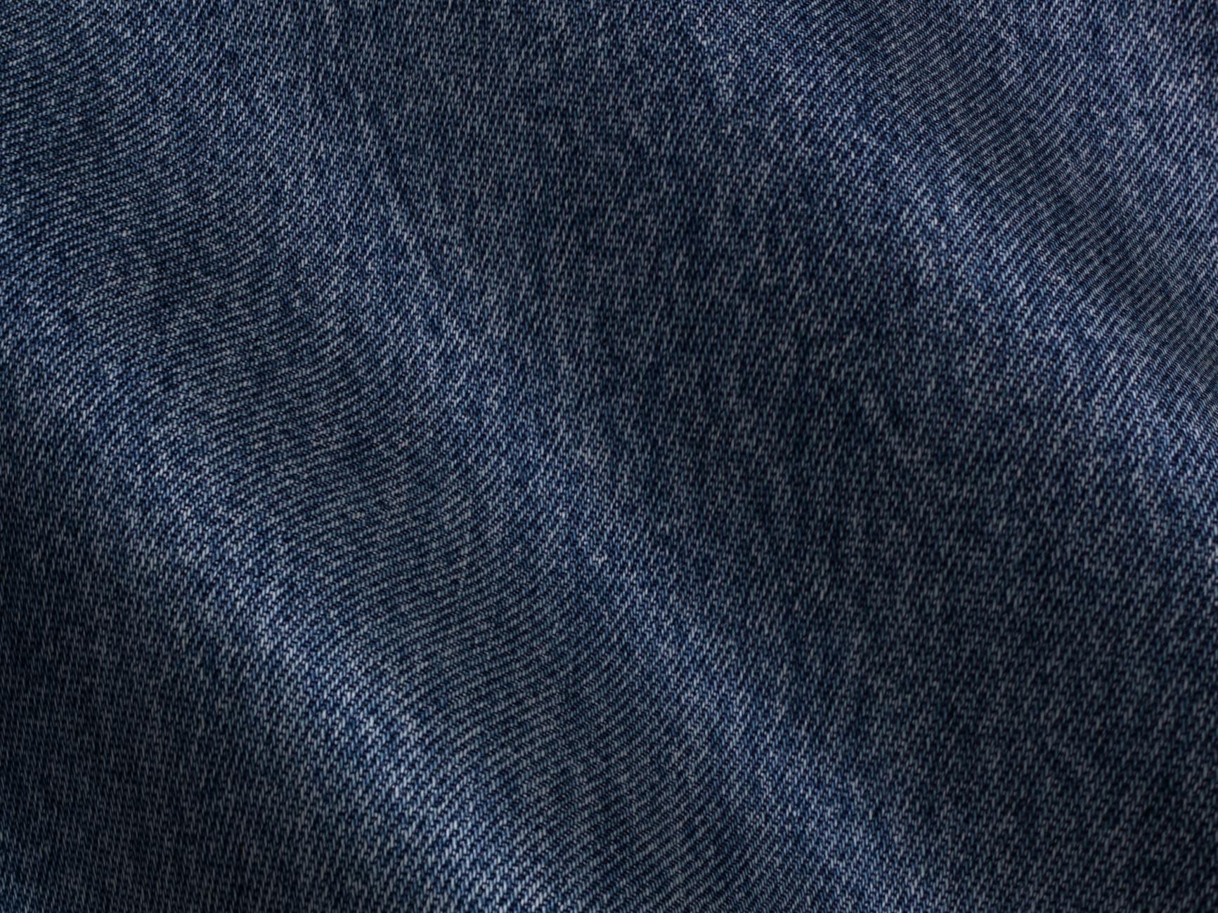 Detailed close-up view of blue denim fabric showcasing texture and pattern.