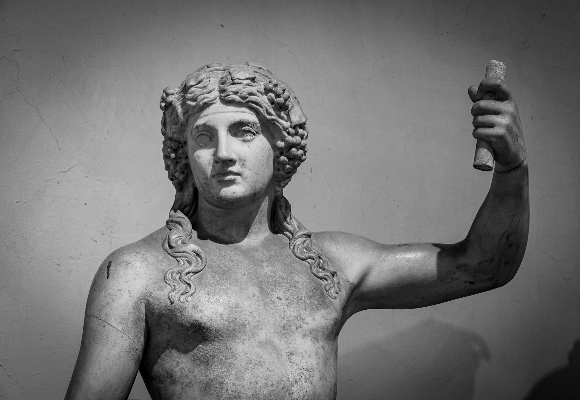 Detailed view of an ancient Roman marble statue depicting a majestic god with intricate carvings.