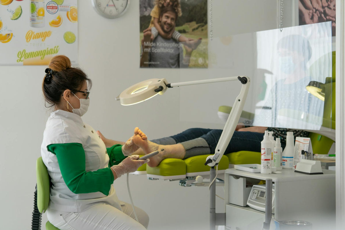 A podiatrist provides foot care to a patient in a clinical setting.