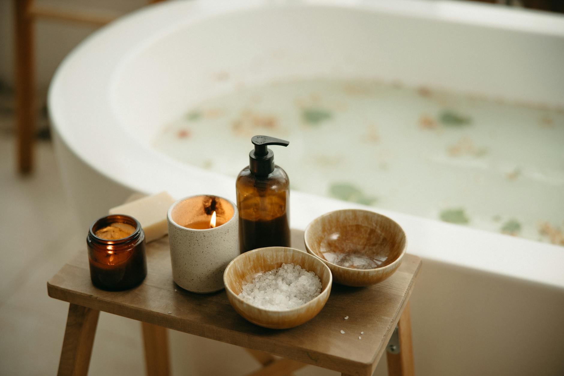 Tranquil bath setting with candles and bath salts, perfect for relaxation and beauty care.