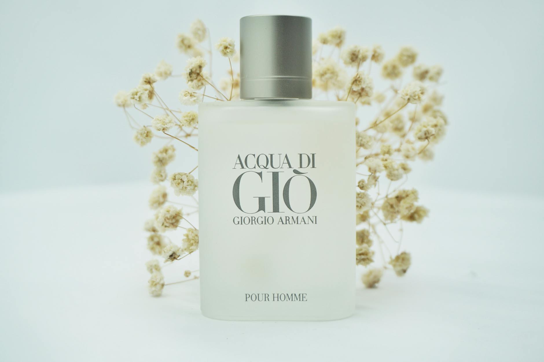 Minimalist product shot of a perfume bottle with delicate floral background.