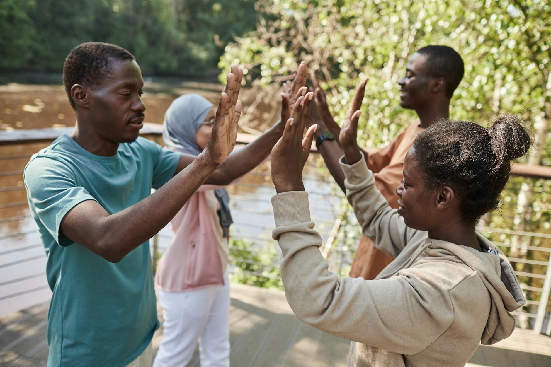 A group of friends enjoying a high-five outdoors, symbolizing camaraderie and joy.